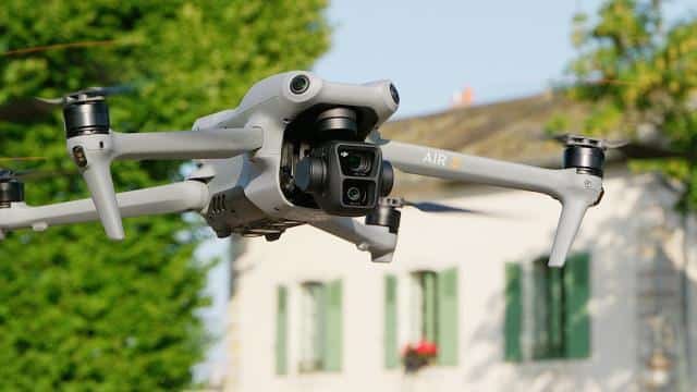 fotografia de DJI air 3 volando con una casa y un arbol de fondo