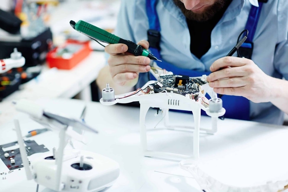 fotografia de primer plano de una persona reparando unos dron dji