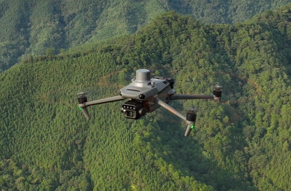 dji mavic 3 multiespectral volando sobre un bosque verdoso con muchos arboles